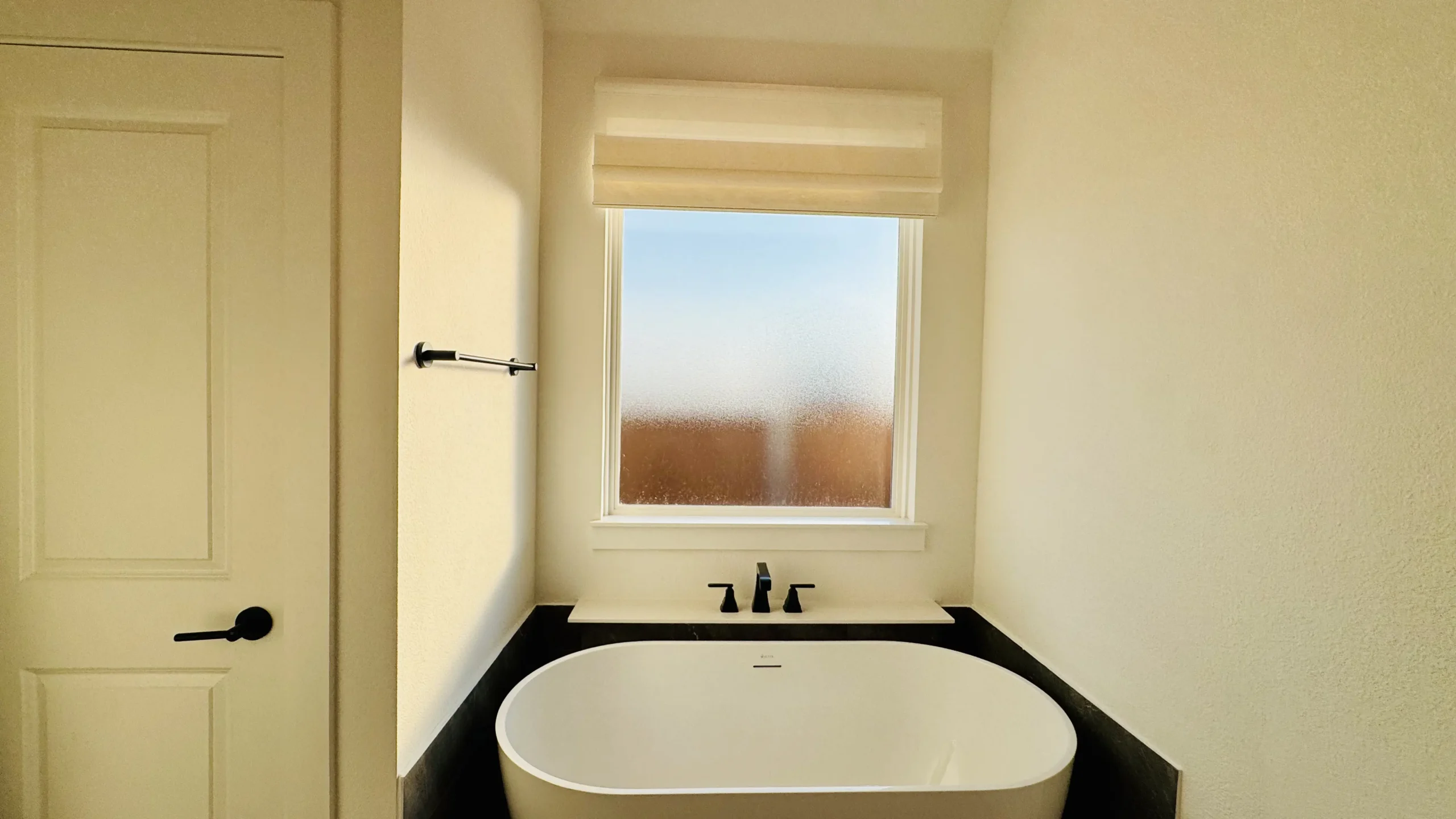 Tailored fabric Roman shades in a bedroom